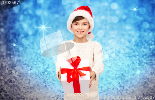 Image of smiling happy boy in santa hat with gift box