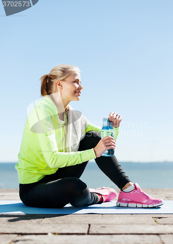 Image of woman resting after doing sports outdoors