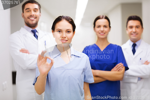 Image of group of medics at hospital showing ok hand sign