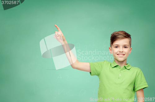 Image of happy boy in green polo t-shirt pointing finger up