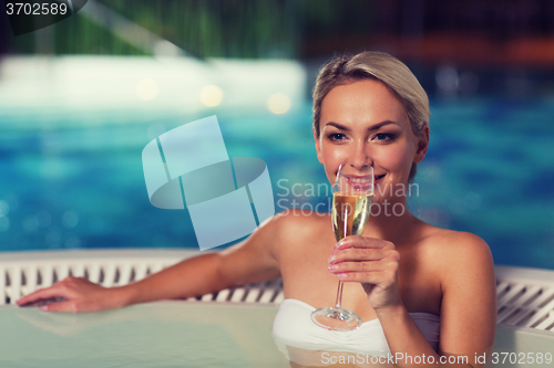 Image of happy woman drinking champagne at swimming pool