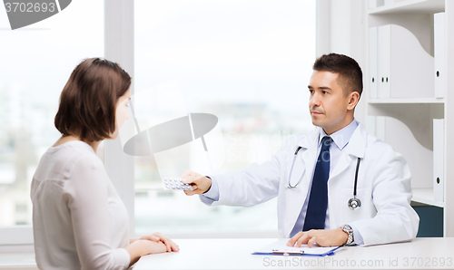 Image of doctor giving pills to woman at hospital