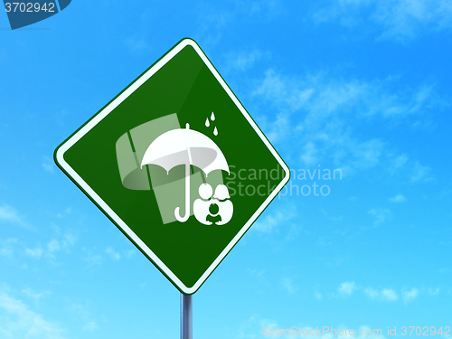 Image of Safety concept: Family And Umbrella on road sign background