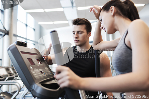 Image of woman with trainer exercising on stepper in gym