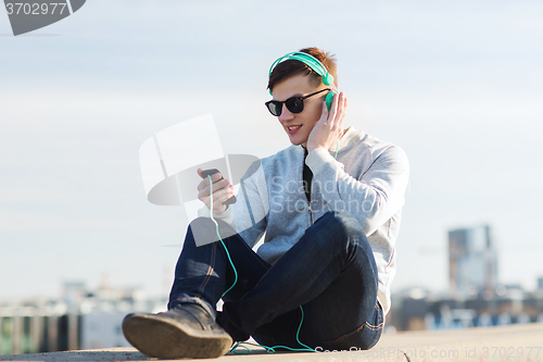 Image of happy young man in headphones with smartphone