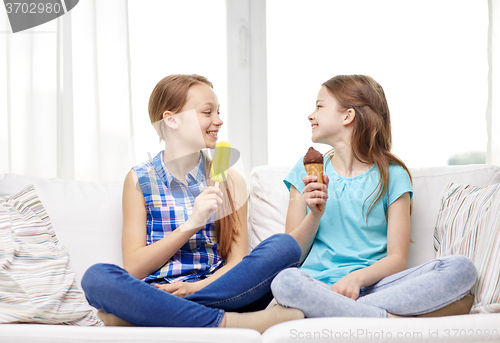 Image of happy little girls eating ice-cream at home