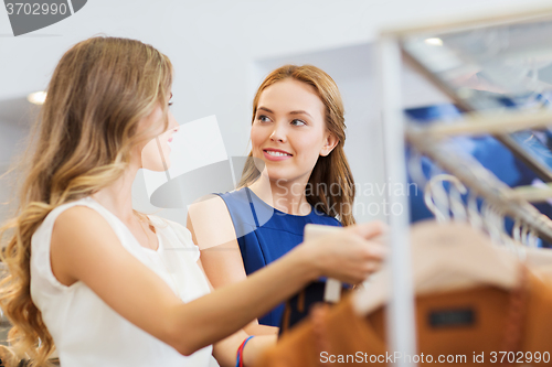 Image of happy women with shopping bags at clothing shop