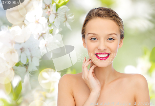 Image of smiling young woman with pink lipstick on lips