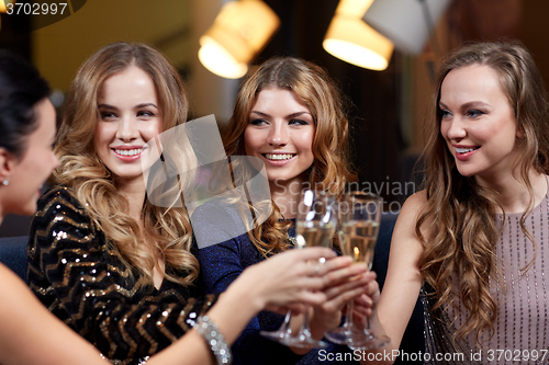 Image of happy women with champagne glasses at night club