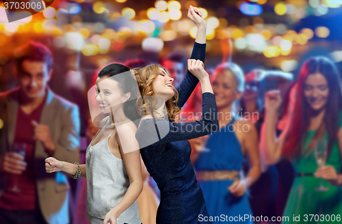 Image of happy young women dancing at night club disco