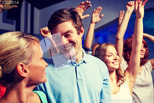 Image of smiling friends at concert in club