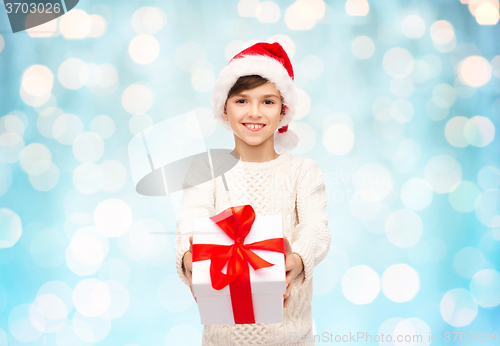 Image of smiling happy boy in santa hat with gift box