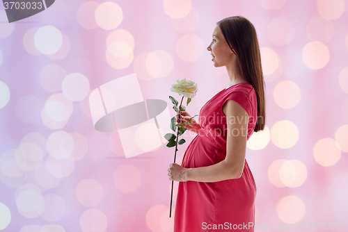 Image of happy pregnant woman with rose flower