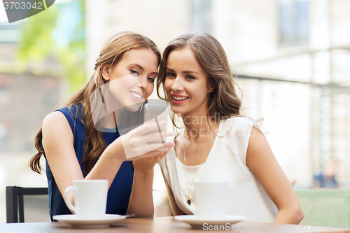 Image of young women with smartphone and coffee at cafe