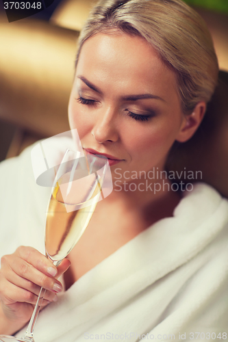 Image of beautiful young woman drinking champagne at spa