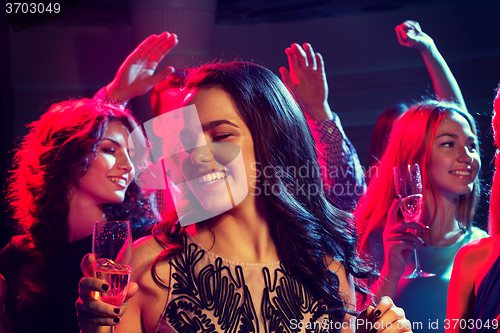 Image of smiling friends with glasses of champagne in club