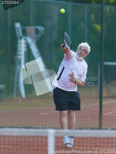 Image of Senior man playing tennis