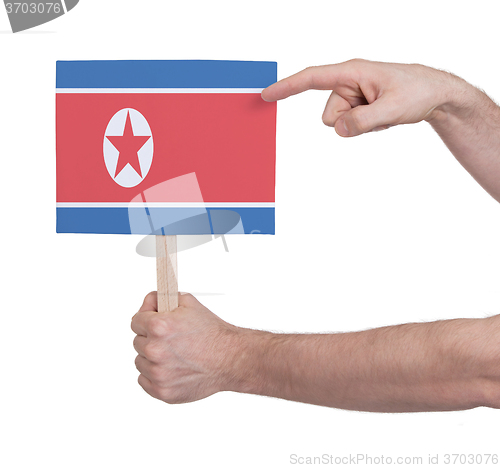 Image of Hand holding small card - Flag of North Korea