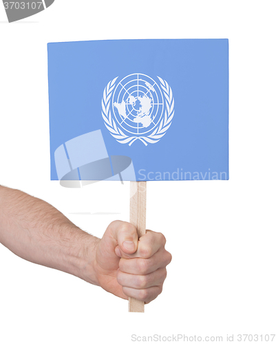 Image of Hand holding small card - Flag of the UN