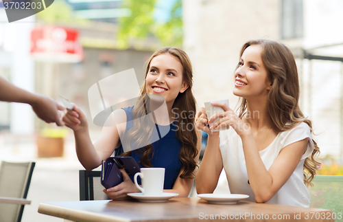 Image of women with credit card paying for coffee at cafe