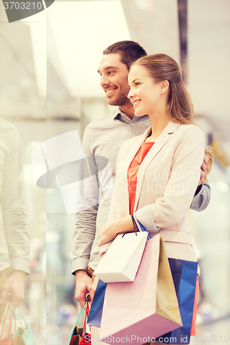 Image of happy young couple with shopping bags in mall