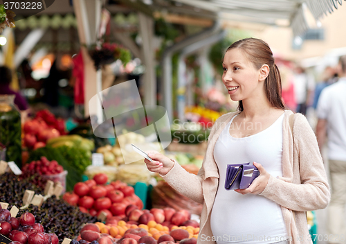 Image of pregnant woman with credit card at street market