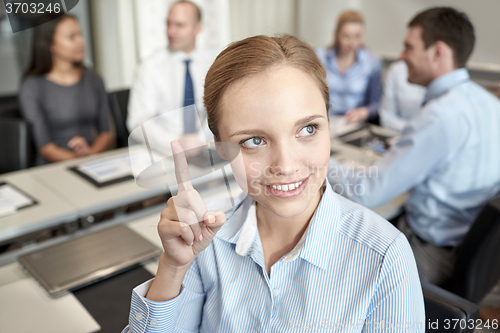 Image of group of smiling businesspeople meeting in office