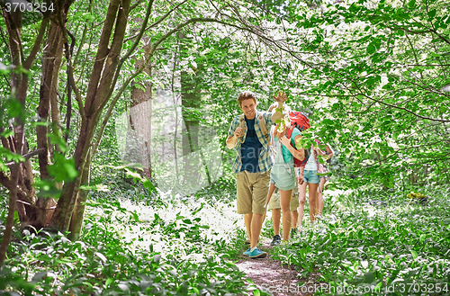 Image of group of smiling friends with backpacks hiking