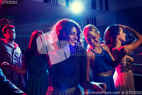 Image of smiling friends dancing in club