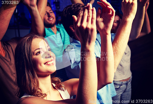 Image of smiling friends at concert in club