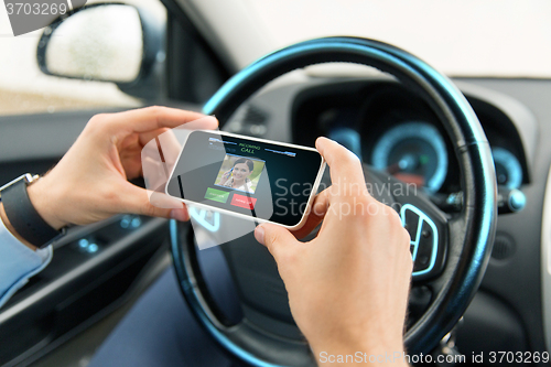 Image of male hands with video call on smartphone in car
