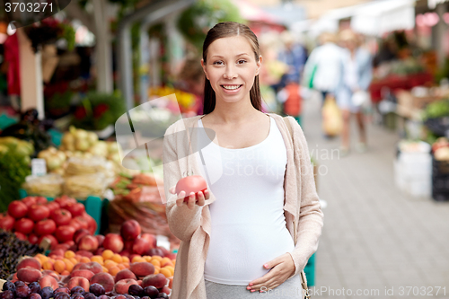 Image of pregnant woman choosing food at street market