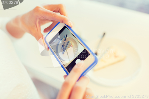 Image of woman hands with smartphone taking food picture