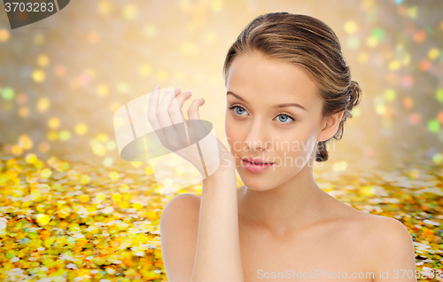 Image of woman smelling perfume from wrist of her hand