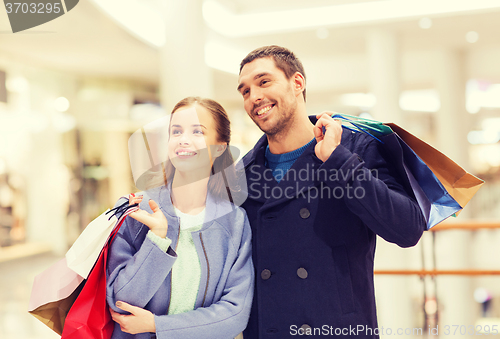 Image of happy young couple with shopping bags in mall