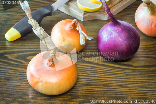 Image of The still life: large onion and lemon on the table.