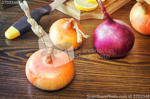 Image of The still life: large onion and lemon on the table.