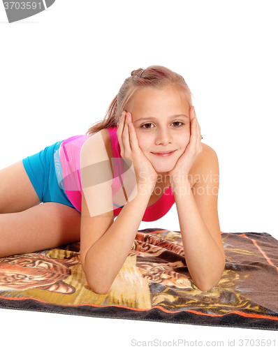 Image of Closeup of young girl lying in bathing suit on floor.