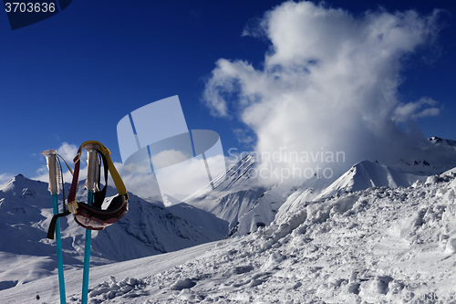 Image of Ski mask on ski poles and off-piste slope