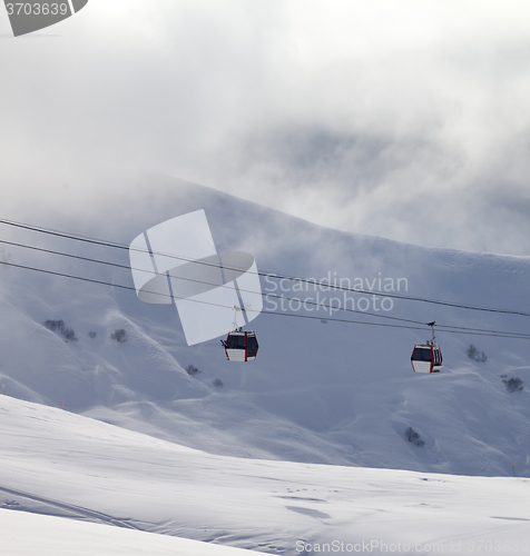 Image of Gondola lifts and off-piste slope in mist