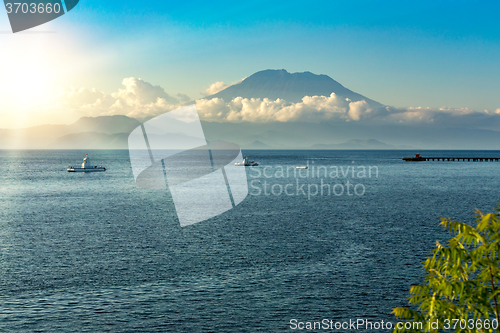 Image of view on Bali from ocean, vulcano in clouds