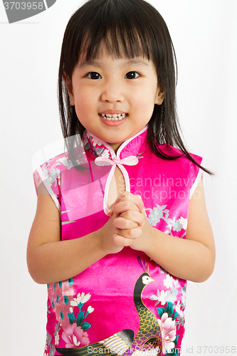 Image of Chinese Little Girl wearing Cheongsam with greeting gesture