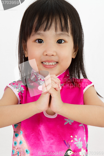 Image of Chinese Little Girl wearing Cheongsam with greeting gesture