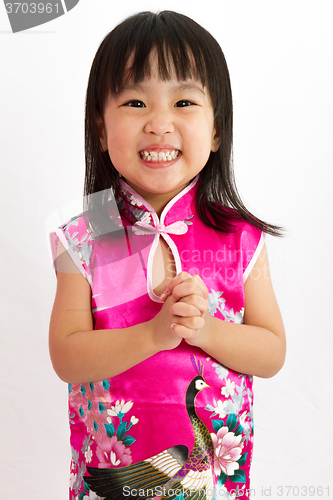 Image of Chinese Little Girl wearing Cheongsam with greeting gesture