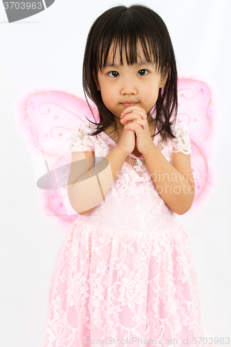 Image of Chinese little girl wearing butterfly custome with praying gestu