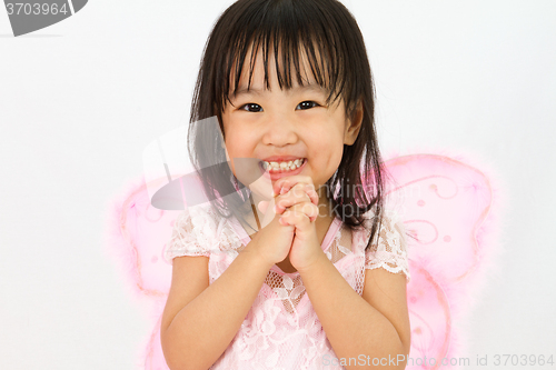 Image of Chinese little girl wearing butterfly custome with praying gestu