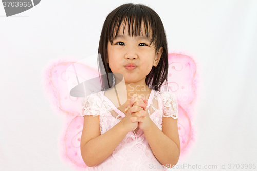 Image of Chinese little girl wearing butterfly custome with praying gestu