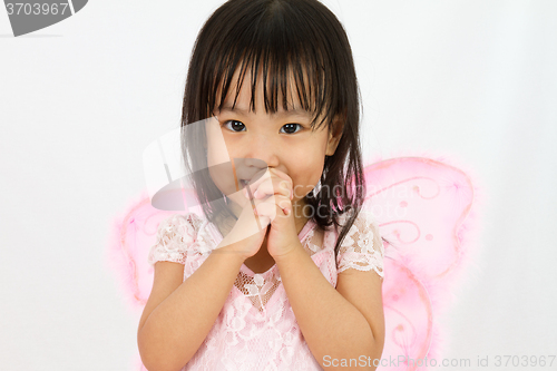 Image of Chinese little girl wearing butterfly custome with praying gestu