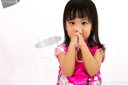 Image of Chinese little girl wearing Cheongsam praying