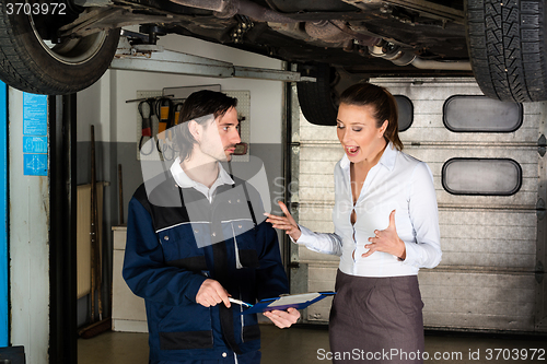 Image of Car mechanic with angry female customer